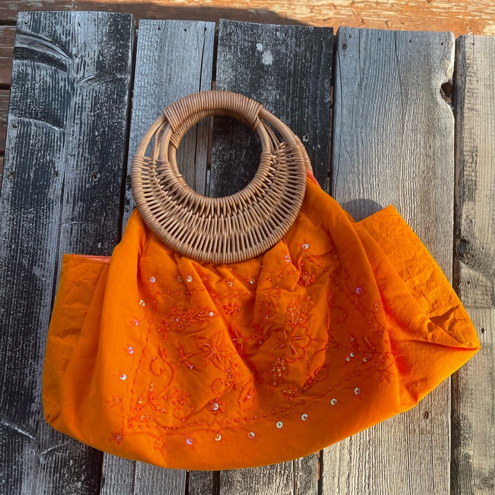 Orange mid-size bag with lace detail and wooden handles